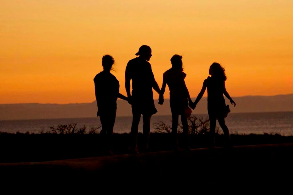 Família de mãos dadas ao pôr do sol